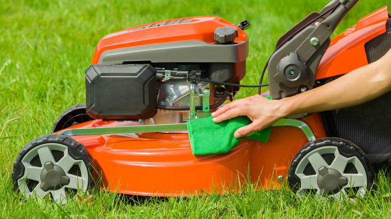 Person cleaning up their lawn mower