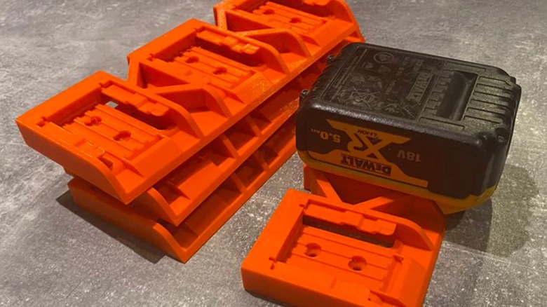 3D printed DeWalt battery holders on concrete.