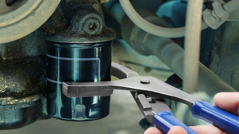person using oil filter wrench