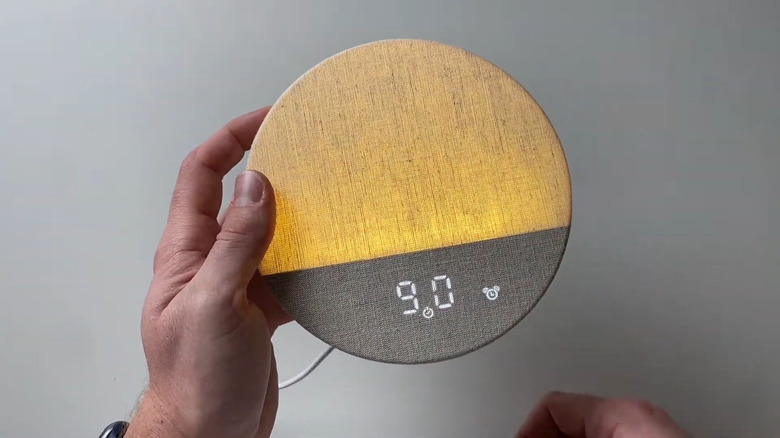 A Dreamegg Sunrise Alarm Clock held in hand.