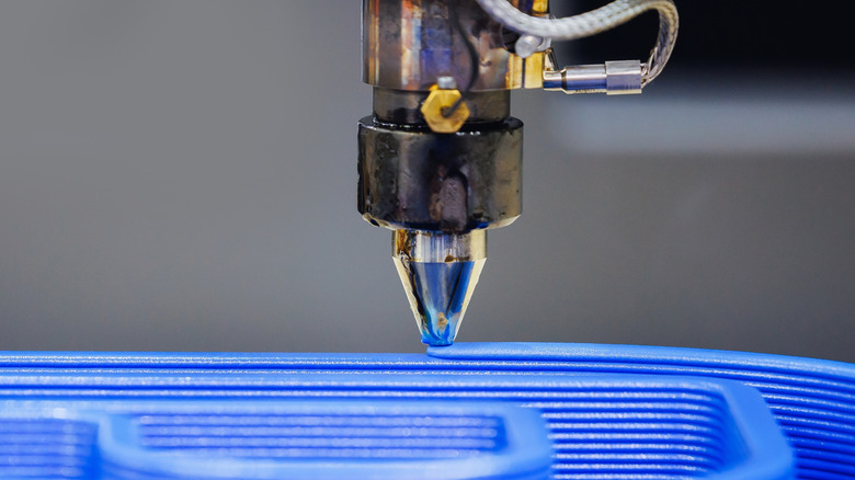 A close-up of a 3D printer laying filament.
