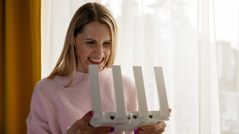 A person holding a router with an angry expression on their face