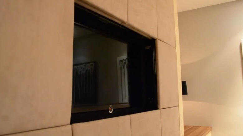 A TV hidden within wall panels.