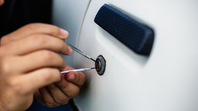 Hands picking car door lock