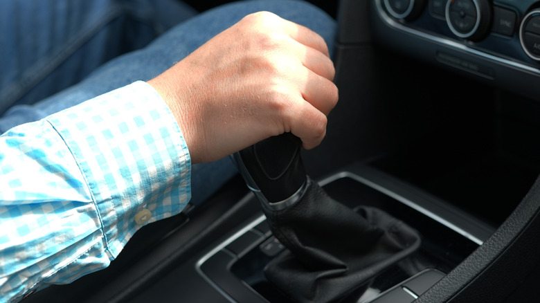 Close view of hand on shift lever of a manual transmission