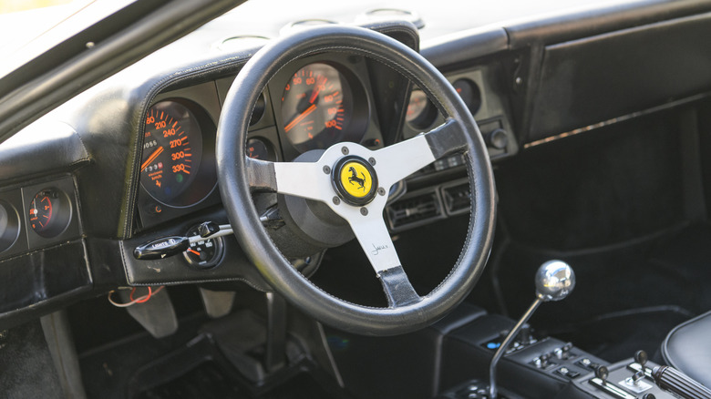 Interior of Ferrari Testarossa showing steering wheel and manual transmission shift lever