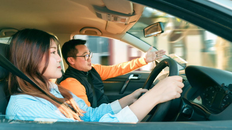 young driver with a driving instructor