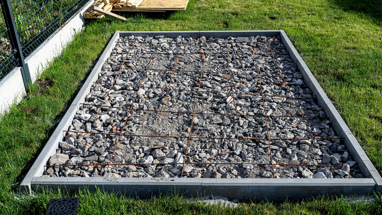 Protected foundation of a shed in a back yard.