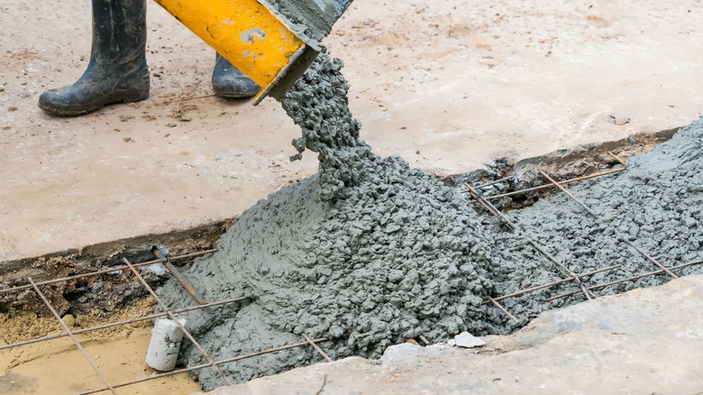 Concrete being poured onto a surface.
