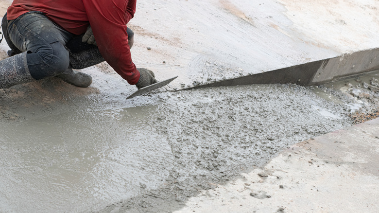 Person smoothing a length of cement floor.