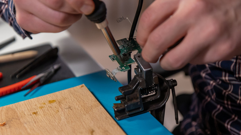 Person soldering clipped circuit board