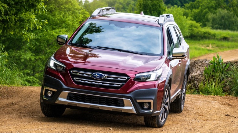 A Subaru Outback traversing a dirt road away from the pavement.