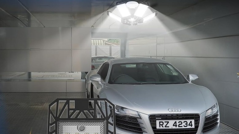 A garage light over a silver car.