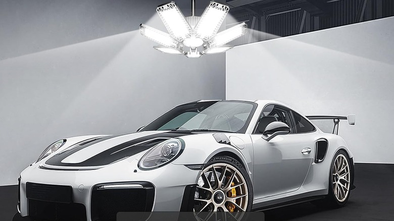 A car over a garage light, shinning down.