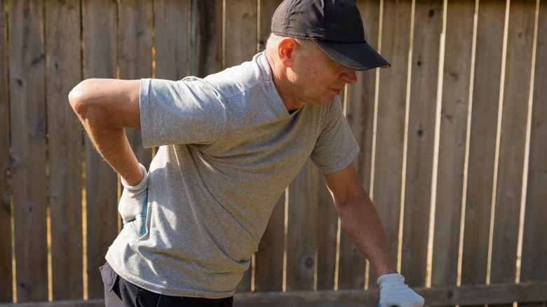 Person working in their yard with back pain