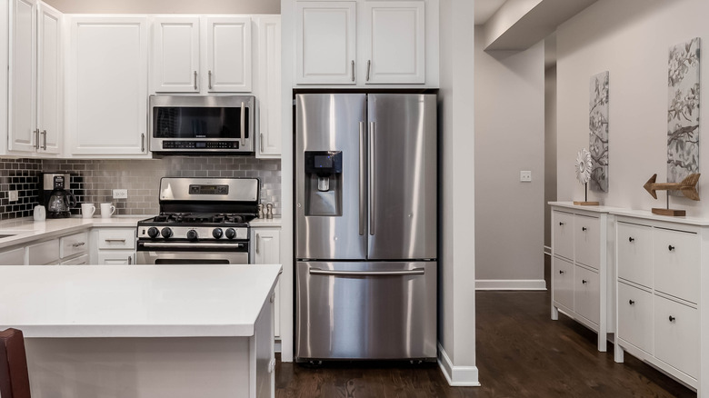A modern kitchen with white cabinets and a large stainless steel Samsung French-door refrigerator.