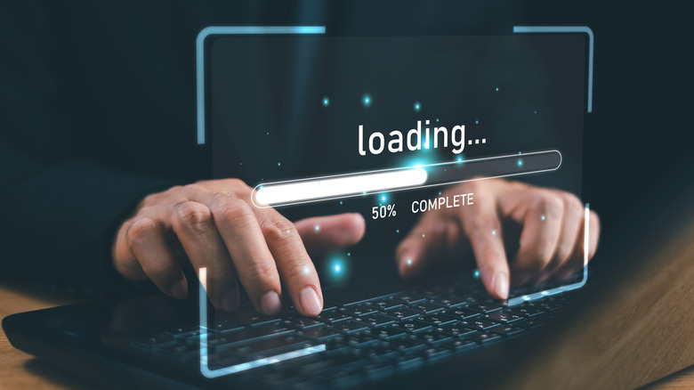 Hands over a keyboard with a loading graphic overlayed on top showing incomplete progress