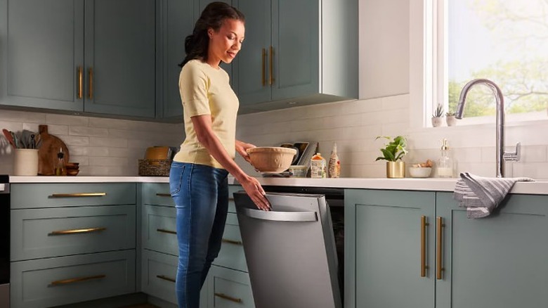 Woman opening Whirlpool dishwasher