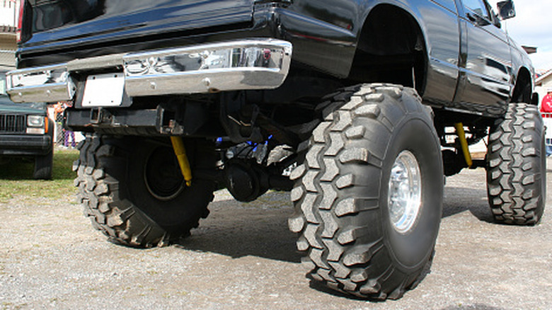Truck with oversized tires photographed from rear side