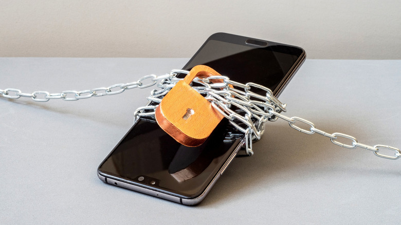 A smartphone wrapped in chains and secured with a lock