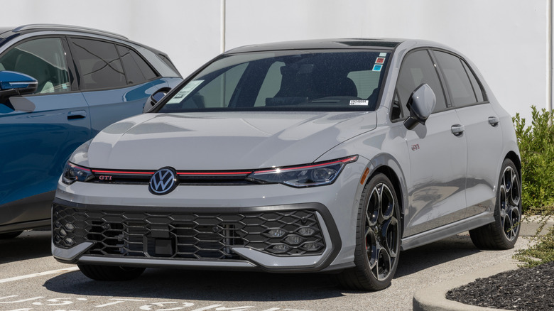 A Mk8.5 Volkswagen Golf GTI in gray outside a dealership, front 3/4 view