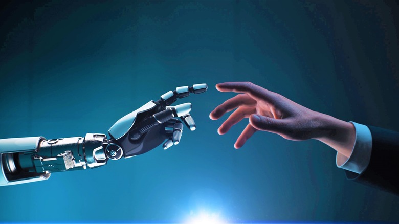 human and robot hands reaching