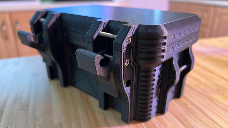 A box-shaped desk organizer on a desk with a tough-looking construction.