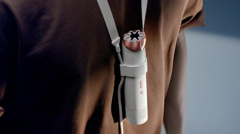 A person wearing a Dyson HushJet fan around their neck