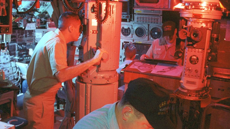 A submarine crew working under red lights