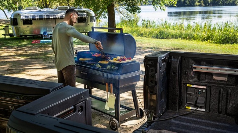 A person powering a grill with Ford's Pro Power Onboard electrical system.