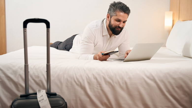 Person working on laptop in a hotel room
