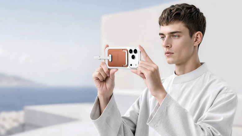 man holding iPhone with portable SSD