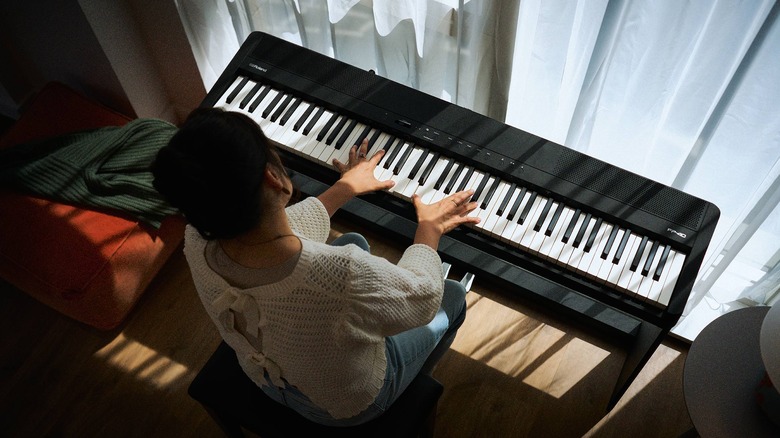 woman playing with digital piano