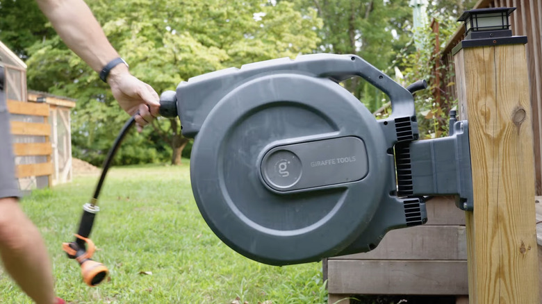 man holding retractable hose