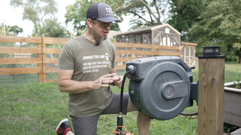 man next to retractable hose