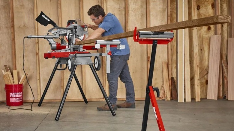 Person cutting board supported by Bauer 250-pound Capacity Roller Stand with Edge Guide