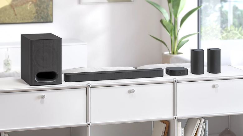 A set of black speakers, a soundbar, a wireless receiver, and a subwoofer from the 5.1-channel Sony Bravia Theater System 6 on a white cabinet.