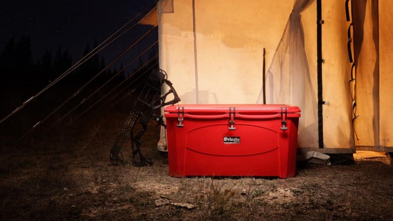 red grizzly cooler in front of a tent