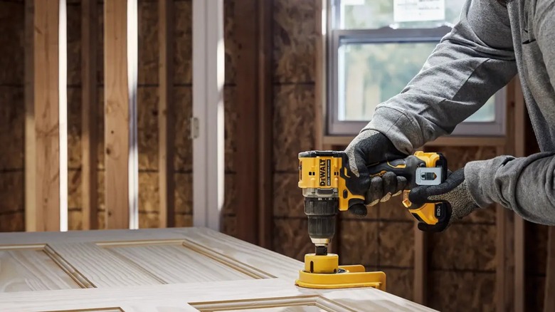 using DeWalt Atomic drill to install door hardware