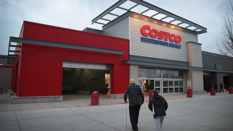 An elderly couple walks toward a Costco Wholesale location