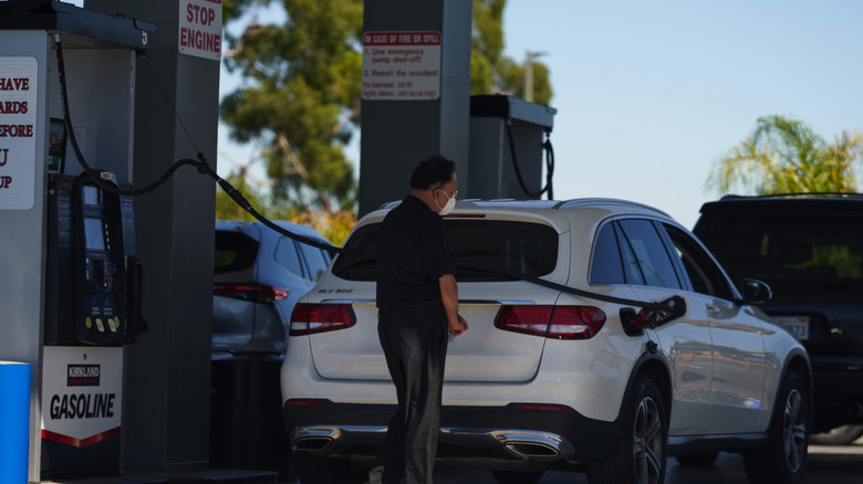man pumps gas into his car at a Costco gas station