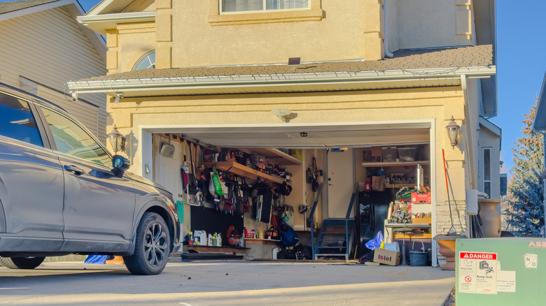 Picture showing a car parked in front of a home's garage