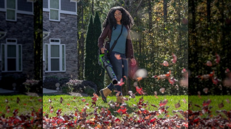 A woman using Greenworks leaf blower in her garden