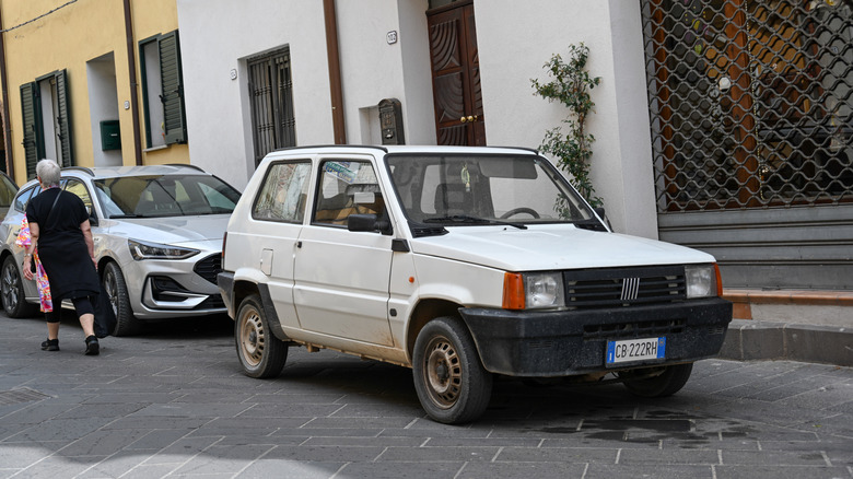 A white Fiat Panda parked outside a building in Sardinia, Italy.