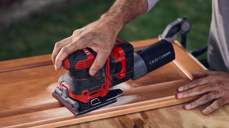 Craftsman V20 1/4 sheet sander being used to sand a cabinet door.