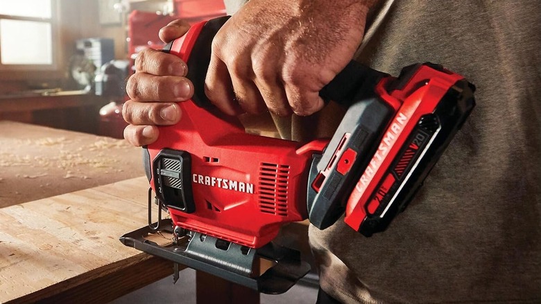 Craftsman V20 jigsaw being used to cut through a laminated wood sheet.