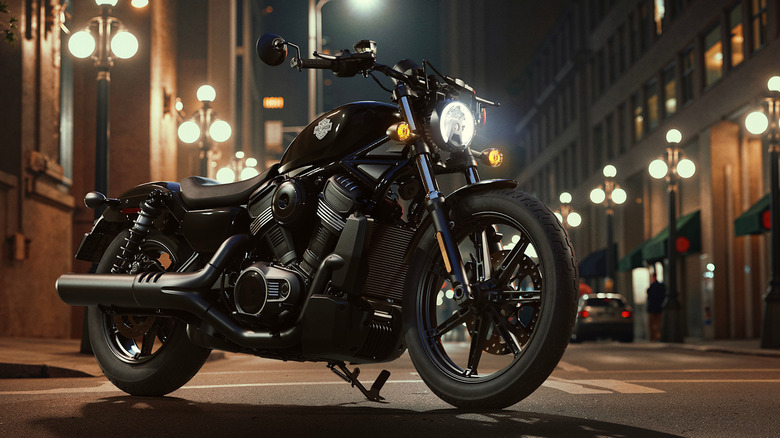 A black Harley-Davidson Nightster motorbike parked outside on a city street, illuminated by streetlighting.