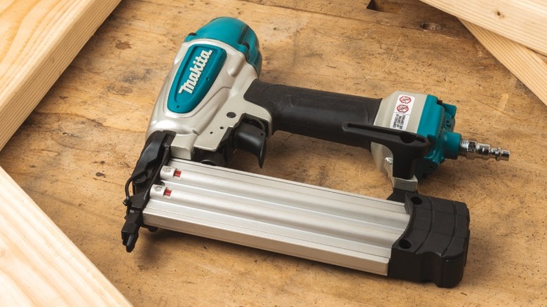 Makita 2-inch 18 Gauge Brad Nailer on its side surrounded by wooden planks