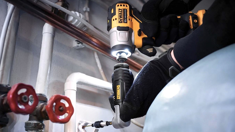 Person using DeWalt right angle drill attachment on a job