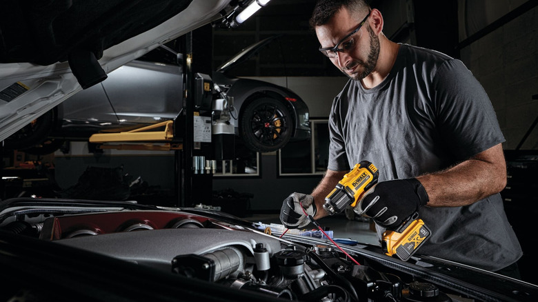 Person using a DeWalt 20V Max Compact Heat Gun on car.